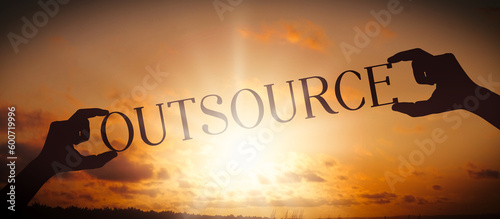 Outsource - human hands holding black silhouette word photo
