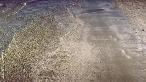 Walking along the beach. Summer holidays. Calm Waves murmur on sandy beach. white and yellow sand.
