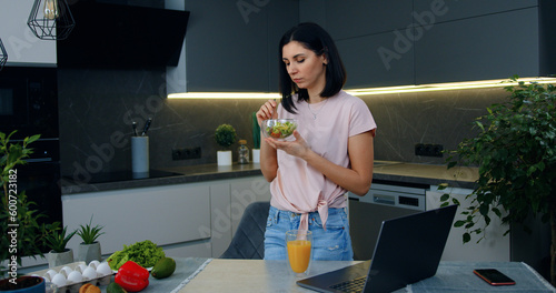 Εκτύπωση καμβά Attractive thoughtful slender young dark-haired woman eating fresh vegetable sal