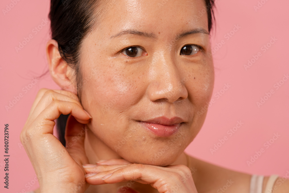 Portrait of smiling mid adult woman touching face Portrait of smiling mid adult woman touching face