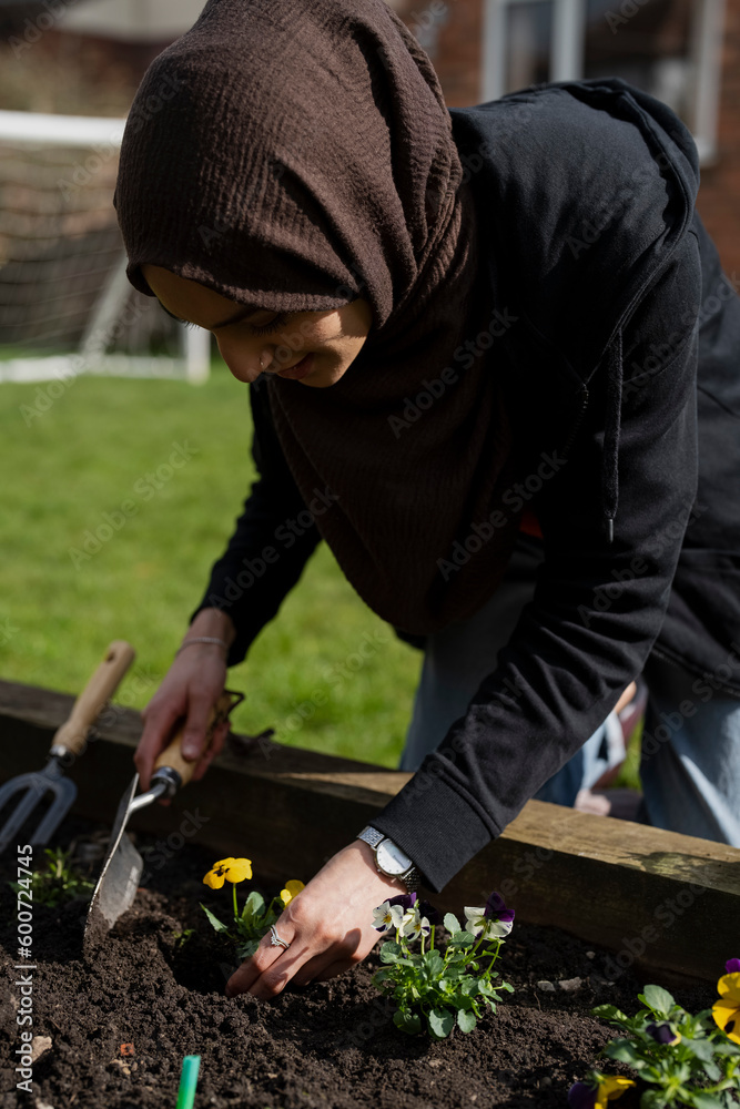 Woman taking care of flowers in garden Woman taking care of flowers in garden