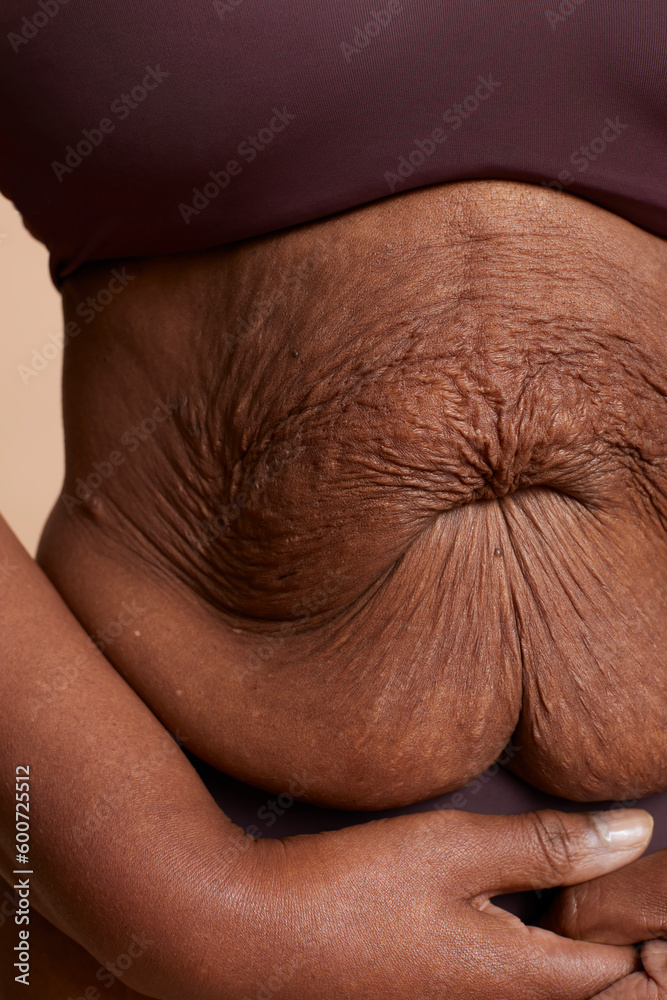 Naklejka premium Close-up view of senior woman wrinkled belly