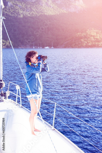 Young woman sailing, looking with binoculars