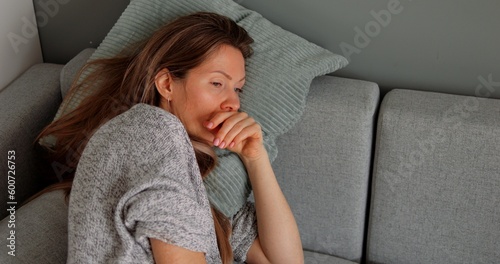 Obraz na plátně Thoughtful or confused disoriented middle age woman lie on sofa pillow