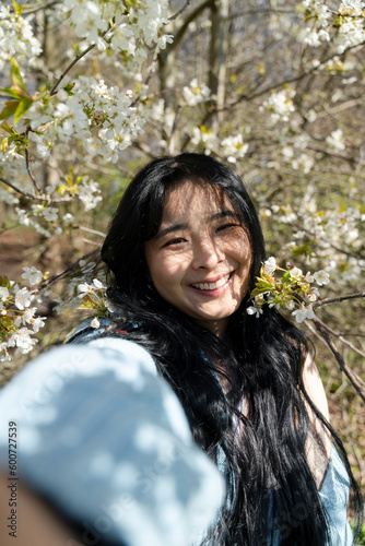 Portrait of young woman among tree blossom