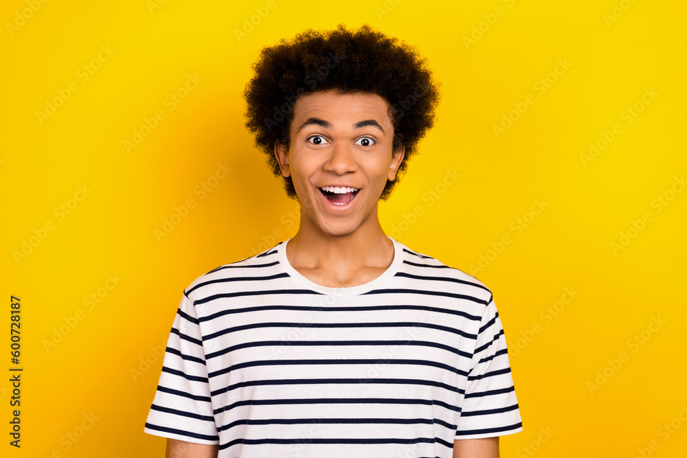 Photo of funky youngster guy overjoyed face open mouth good news wear striped white black t-shirt isolated yellow color background Photo of funky youngster guy overjoyed face open mouth good news wear striped white black t-shirt isolated yellow color background