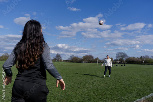 Young women playing soccer outdoors
