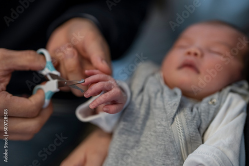 Father trimming baby daughters nails (0-1 months)