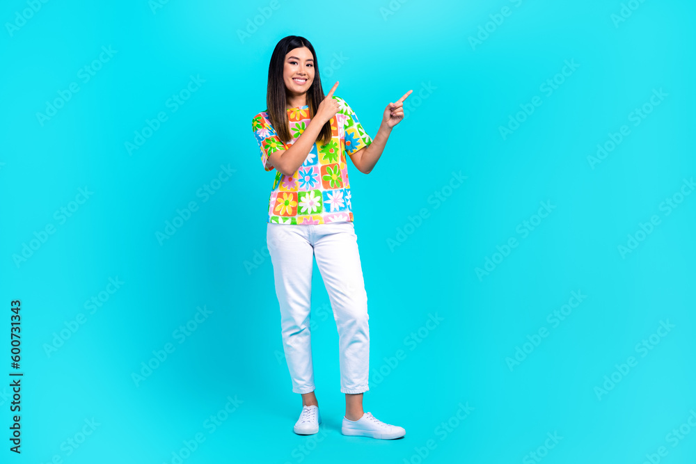 Full body photo of young girl point fingers empty space pants stylish t-shirt recommend clothes boutique isolated over cyan background Full body photo of young girl point fingers empty space pants stylish t-shirt recommend clothes boutique isolated over cyan background