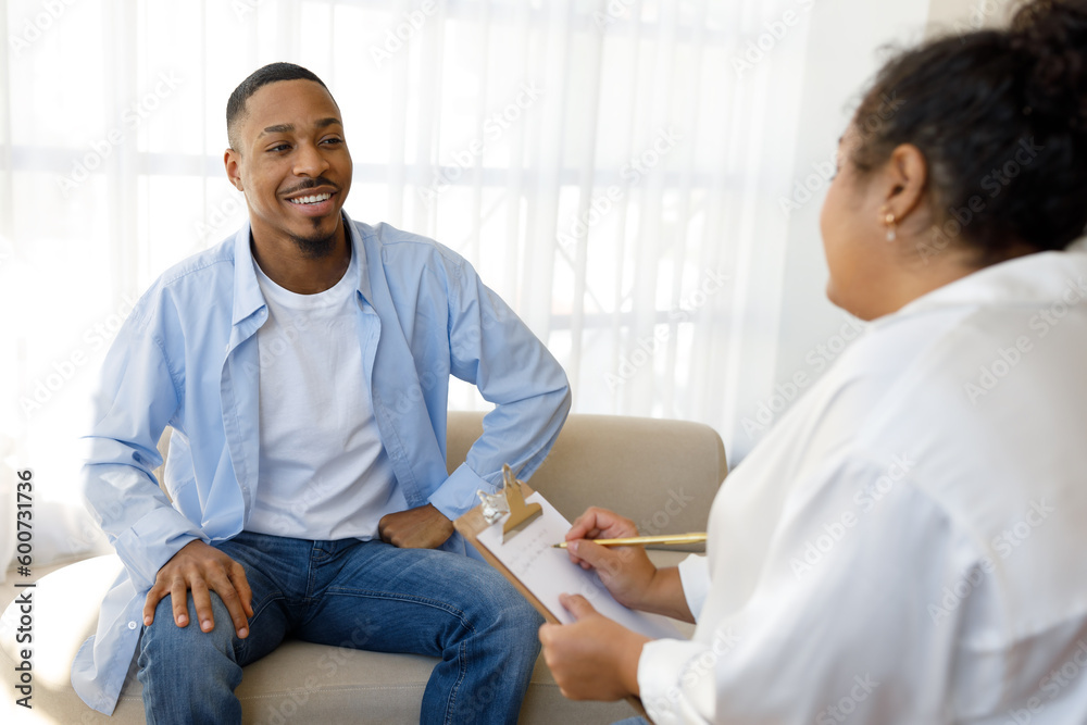 Fototapeta premium Positive black guy sharing good results of therapy with psychologist