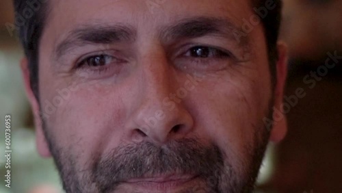 close up of a smiling and well-disposed man with a hood on his head, looks into the room and eats a tradicional food. Lisbon, Portugal, Europe.