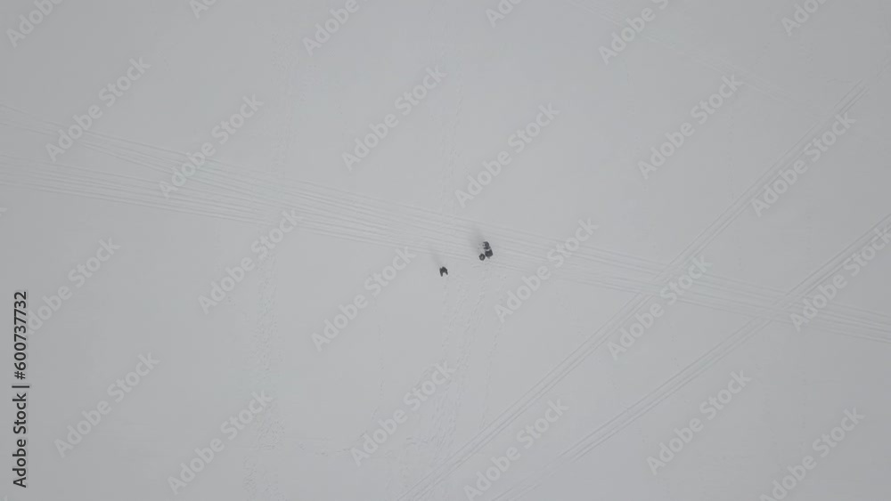 Zooming into people snowshoeing on a frozen lake Zooming into people snowshoeing on a frozen lake