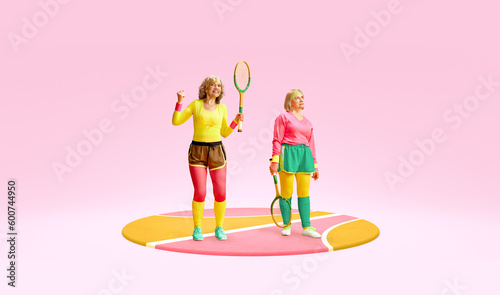 Two senior women in colorful, comfortable sportswear posing with retro tennis rackets over pink background. Winner. Concept of sportive lifestyle, health care, action and motion. Copy space for ad