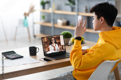 Photography Asian boy studying at home, having video call with teacher