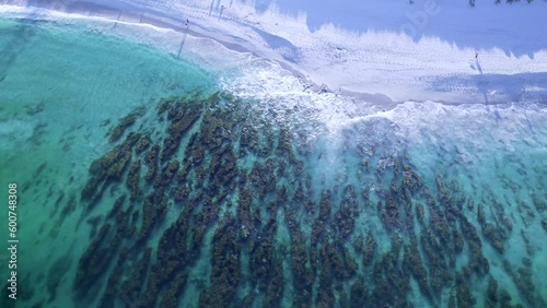 An aerial shot of the beautiful rocks at North Cottesloe Beach, Perth Western Australia. People can be seen walking on their morning beach walk photo