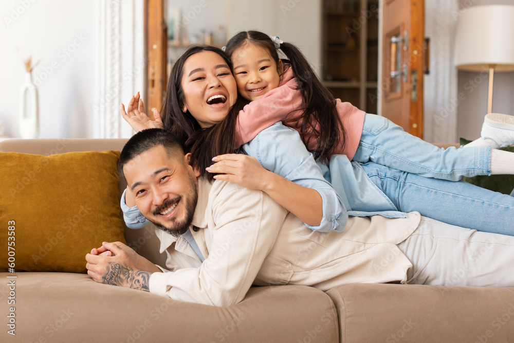 Portrait Of Happy Japanese Family Lying Piled Up At Home Portrait Of Happy Japanese Family Lying Piled Up At Home