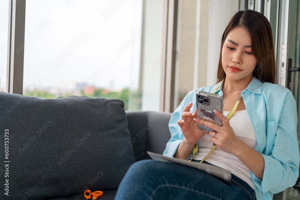 Young woman in casual wear, sits on a sofa, using smart phone, chatting in social media Young woman in casual wear, sits on a sofa, using smart phone, chatting in social media