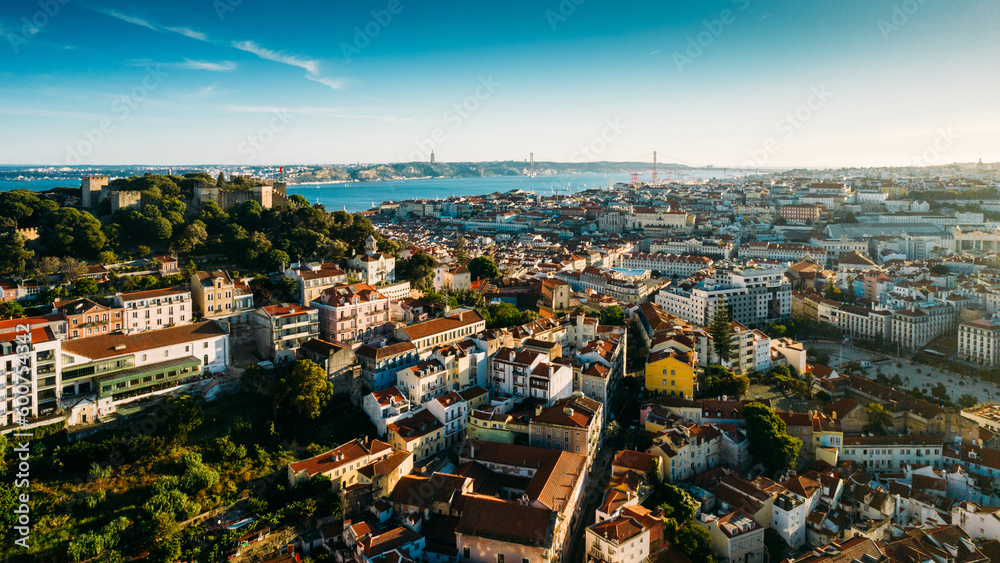 Aerial drone view of Castelo Sao Jorge on foreground with Lisbon, Portugal baixa district in background including 25 April Bridge
