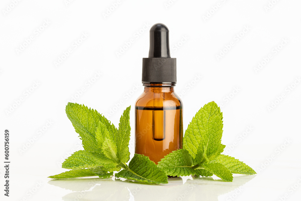 Peppermint essential oil on white background. Herbal remedies Peppermint essential oil on white background. Herbal remedies