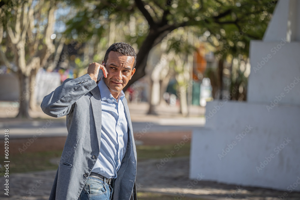 Young latino man talking on the mobile phone seen from behind. Young latino man talking on the mobile phone seen from behind.