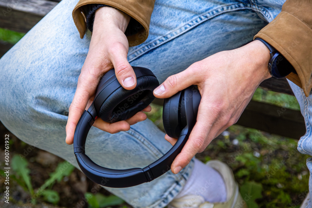 A man holding the headphones in his hands.