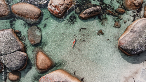 Aerial picture of a girl swimming in a fairy pool in Albany, Australia. Shallow and transparent water. Drone picture. Swimming in paradise in blue water between rocks.