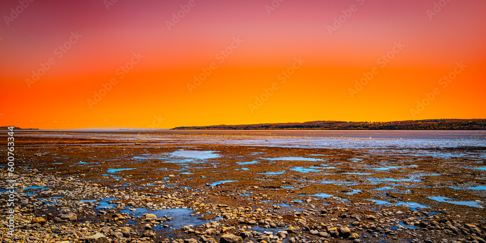 Quebec twilight dramatic sunset landscape over the St. Lawrence River at low tide, with the view of the Ile D'Orleans from Cote de Beaupre near Quebec City, Canada, the view from the Peace Wharf