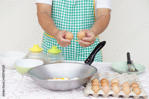 Closeup hand hold eggs for cooking fried eggs menu on frying pan. Concept, love cooking. Fast and easy eggs menu. Food ingredient. Recipe. Kitchen lifestyle. Asian food. High protein     