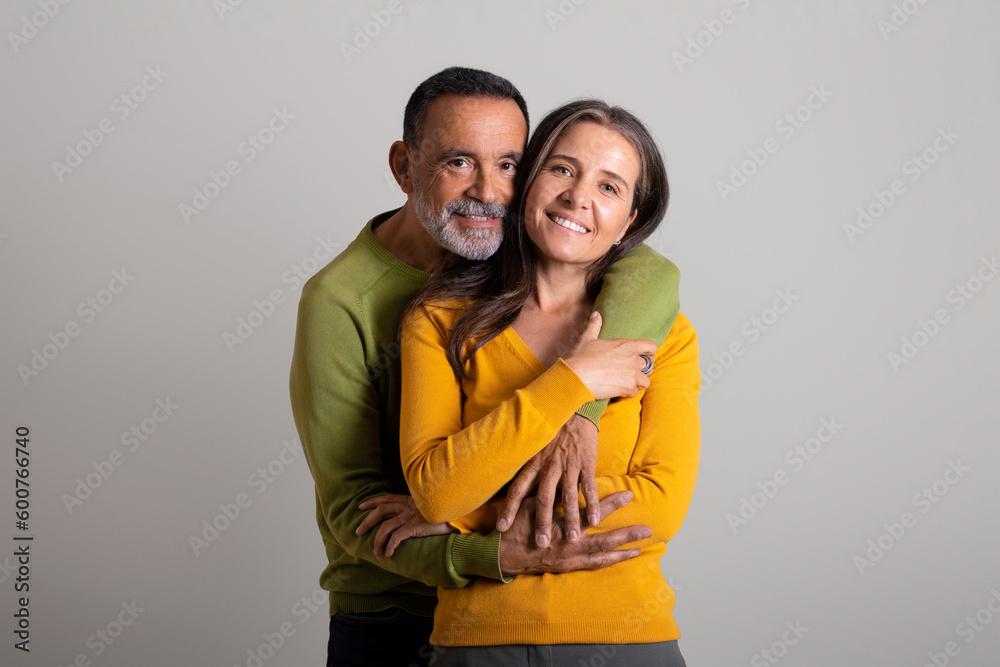 Fototapeta premium Positive caucasian elderly husband hugging his wife, enjoy romantic date and spare time