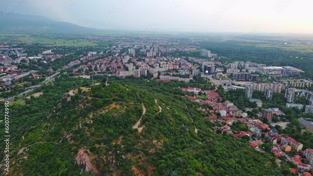 Town Plovdiv with houses and fields against backdrop of Rhodope Mountains and hills covered with forests and cloudy sky Town Plovdiv with houses and fields against backdrop of Rhodope Mountains and hills covered with forests and cloudy sky