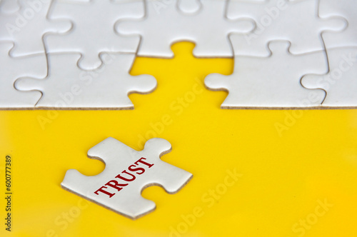 Trust text on missing jigsaw puzzle on yellow background