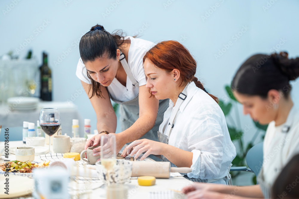 Focused women having pottery master class in studio Focused women having pottery master class in studio
