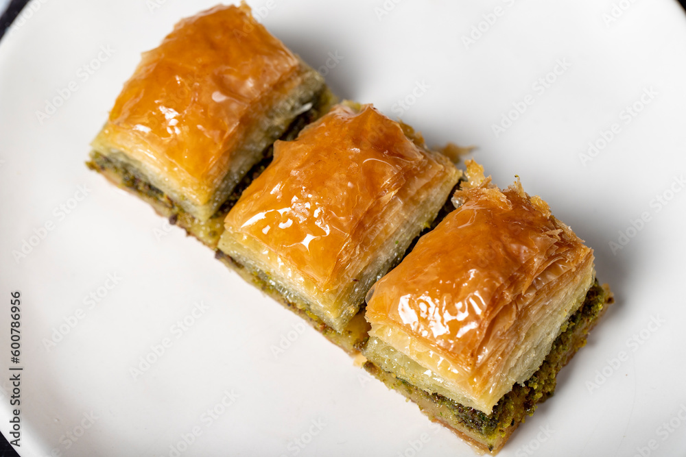 Pistachio baklava. Pistachio baklava with syrup on a dark background. Turkish cuisine delicacies. Close up Pistachio baklava. Pistachio baklava with syrup on a dark background. Turkish cuisine delicacies. Close up