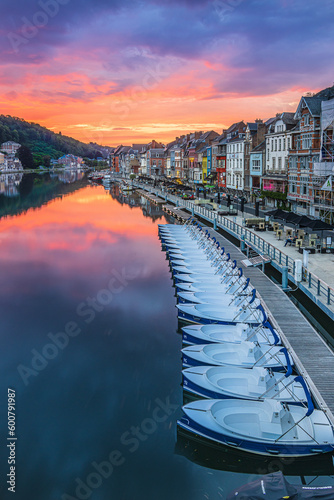 Obraz na płótnie Colorful sunset in Belgium of the city of Dinant. River Maas with old riverside houses. Reflection of houses and sunset on the water surface. Many rowing boats attached to the jetty next to each other w salonie