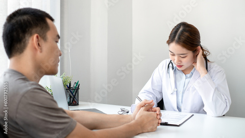 The doctor is explaining the treatment method to the male patient in the hospital.