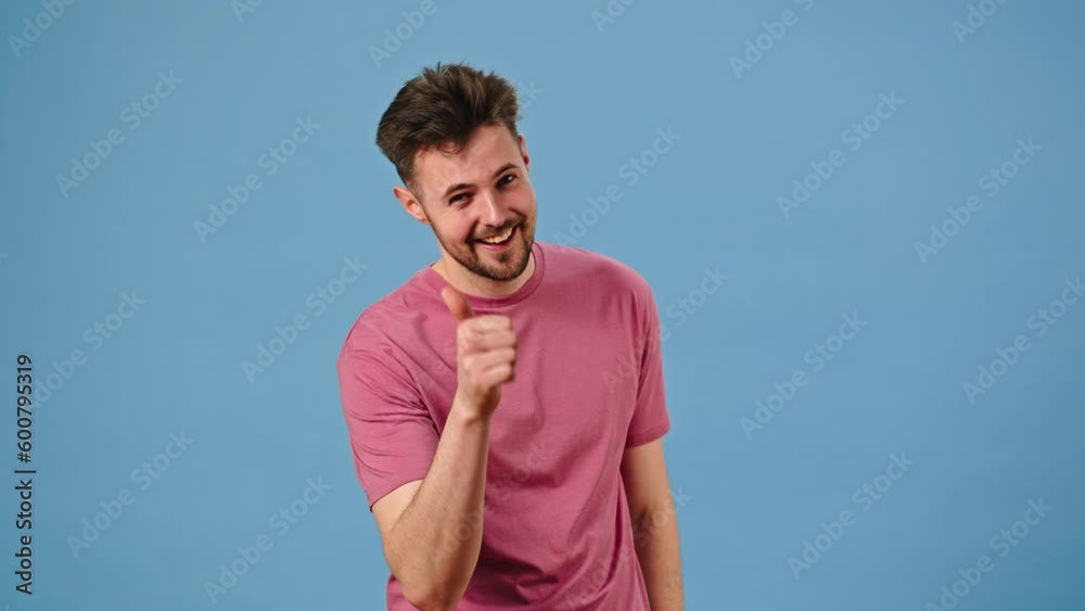 Positive young man points finger and makes hand shot gesture Positive young man points finger and makes hand shot gesture