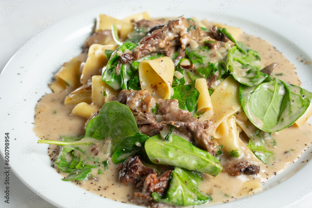 A view of a plate of short rib pappardelle. A view of a plate of short rib pappardelle.