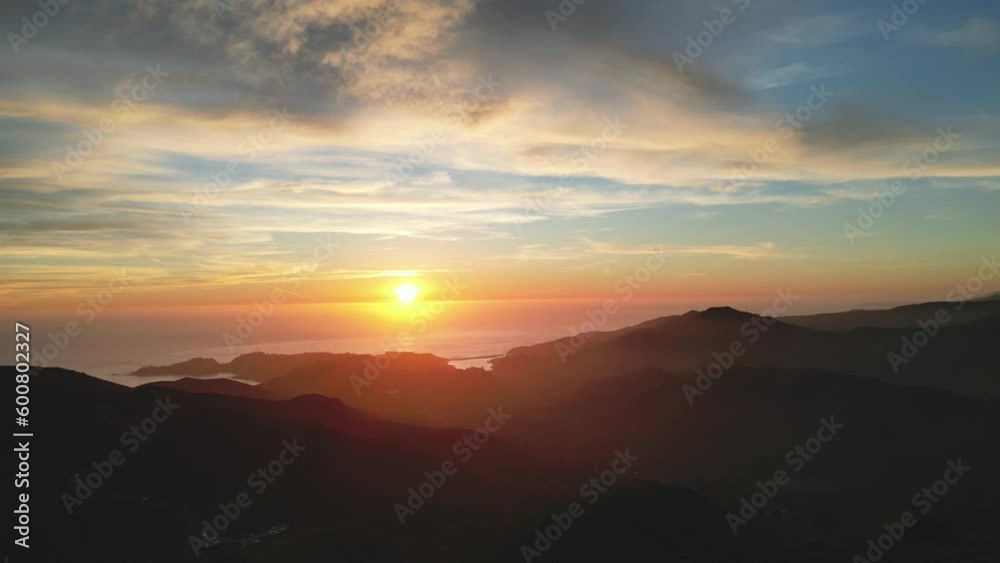 Beautiful sunset color in sky along rugged silhouetted coastal hills Beautiful sunset color in sky along rugged silhouetted coastal hills