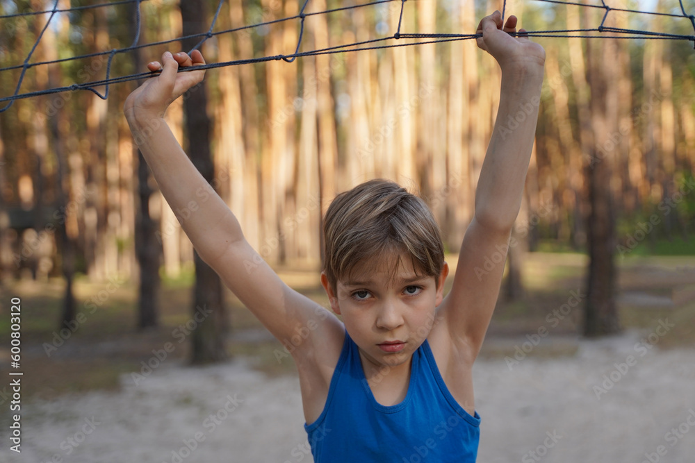 Fototapeta premium Cute cheerful boy near volleyball net. Healthy lifestyle of adolescents