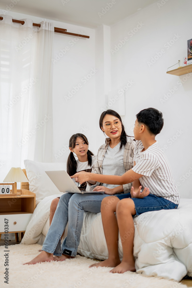 Asian Mother Teaching Children Online Learning on Laptop in white room of Home Happy Smile Asian Mother Teaching Children Online Learning on Laptop in white room of Home Happy Smile