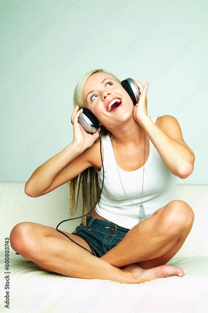 Naklejka premium Young beautiful happy women listening music in headphones