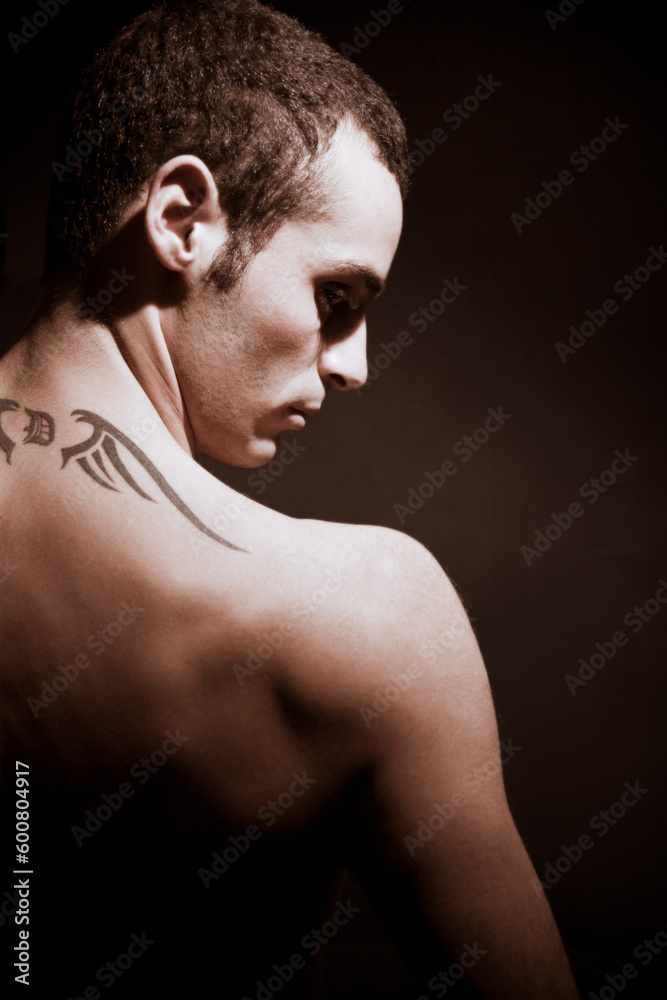 man seen from behind showing his tattoo on his shoulders man seen from behind showing his tattoo on his shoulders