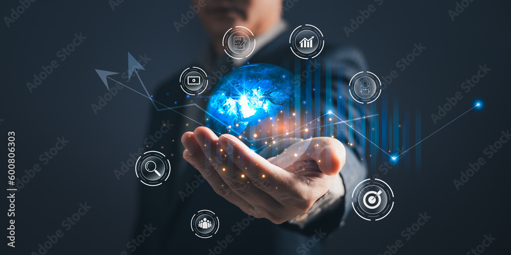 A person holding global and graph stock to plan in e-business, the use of online digital network technology in business, buying and selling commerce online digital marketplace A person holding global and graph stock to plan in e-business, the use of online digital network technology in business, buying and selling commerce online digital marketplace