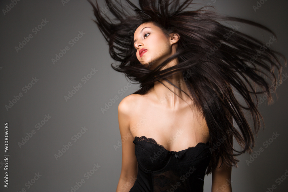 Portrait of pretty young woman flinging long black hair into air. Portrait of pretty young woman flinging long black hair into air.