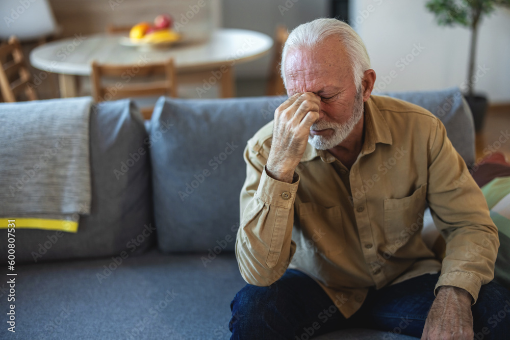 Shot of a handsome senior man suffering with a headache at home. Shot of a handsome senior man suffering with a headache at home.