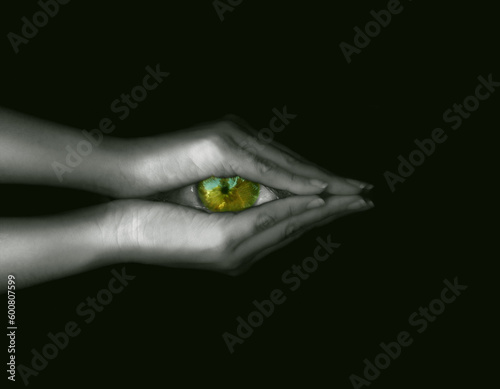 Hand holding green eye photo