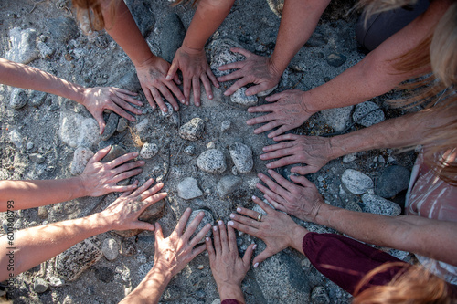 Women's hands in a circle on the earth. 