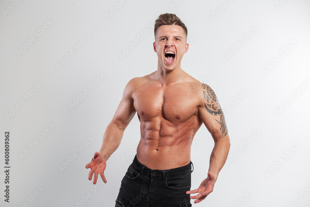 Strong athlete handsome man with emotions with muscular body screaming on a white background in the studio Strong athlete handsome man with emotions with muscular body screaming on a white background in the studio