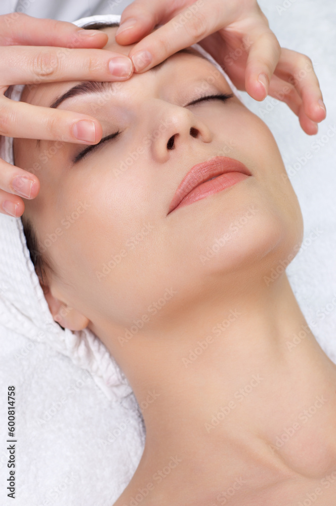 pretty woman getting facial massage in the beauty salon