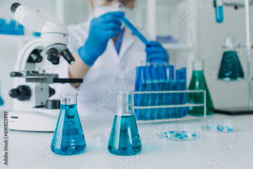 Medical Development Laboratory: Caucasian Female Scientist Looking Under Microscope, Analyzes Petri Dish Sample. Specialists Working on Medicine, Biotechnology Research in Advanced Pharma Lab © ARMMY PICCA